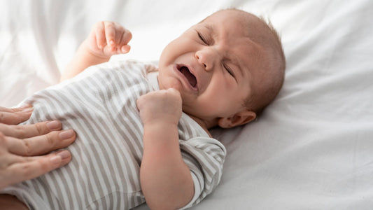 Un bébé qui pleure poing serré.