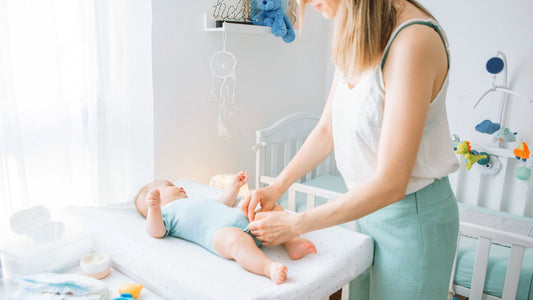 Une maman qui change la couche de son bébé.