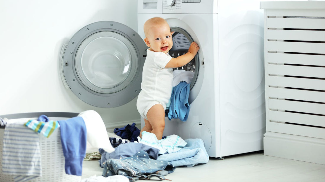 Un enfant qui met du linge dans la machine à laver.