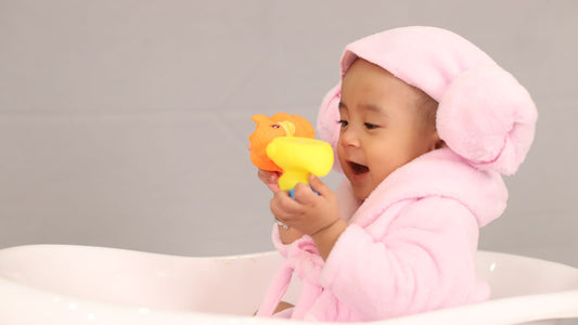 un bébé avec une cape de bain rose
