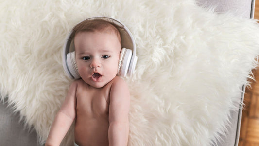 Un bébé portant un casque anti-bruit allongé sur un tapis