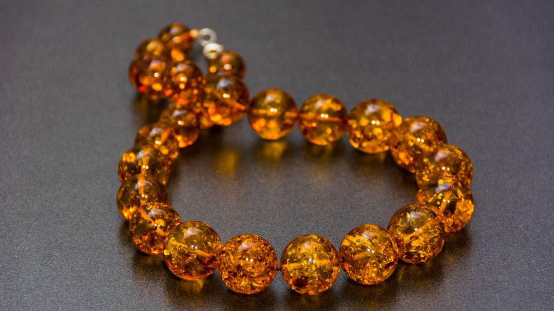 un collier d'ambre pour bébé posé sur une table grise