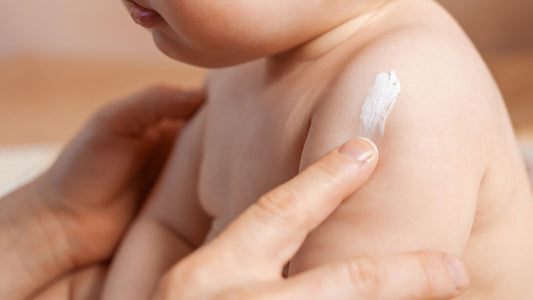 une maman appliquant de la crème solaire sur un bébé de 3 ans