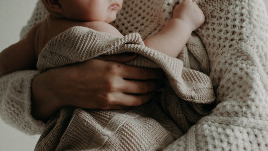 un bébé tenu dans les bras de son parent