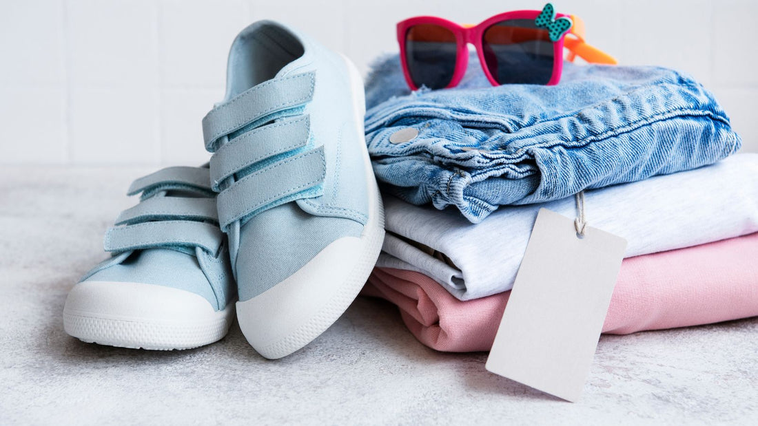 un ensemble de vêtement pour enfant composé de chaussures, lunette de soleil, d'un jean, d'un t-shirt et d'un sweat