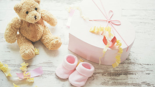 Un ours en peluche, des chaussons rose et un cadeau.