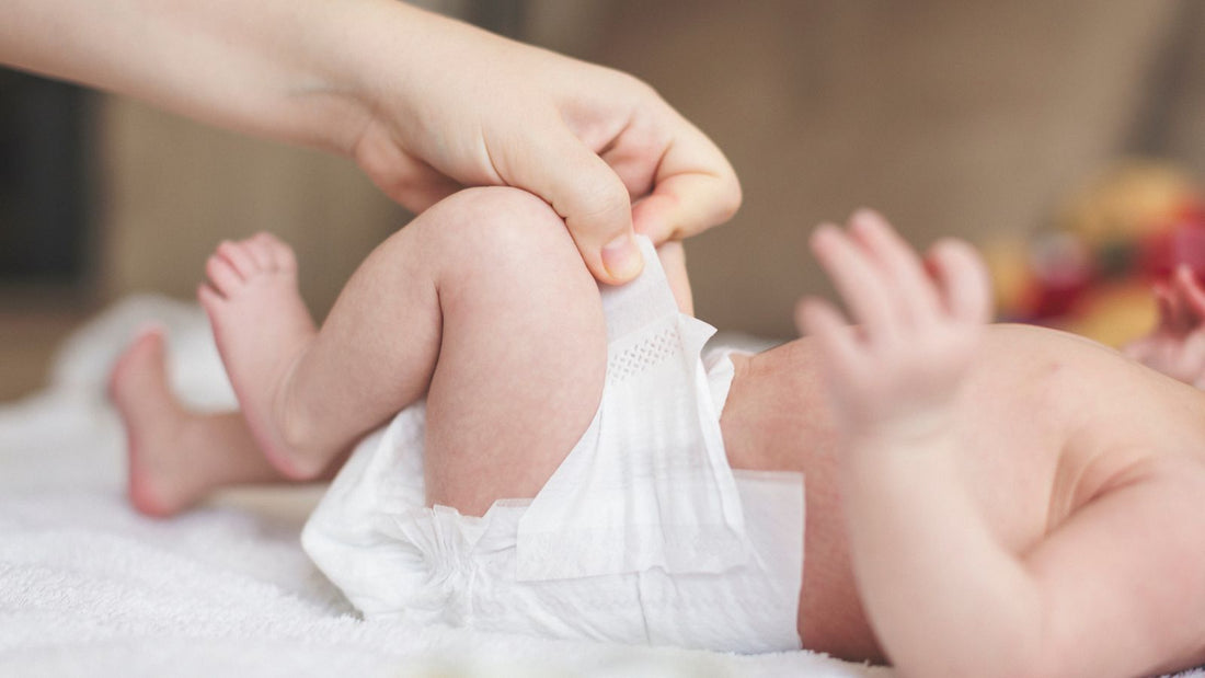 un parent ajustant la couche de bébé