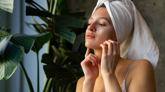 Une femme qui met de la crème sur son visage.