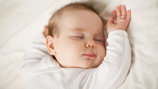 Un bébé endormi avec les en l'air.