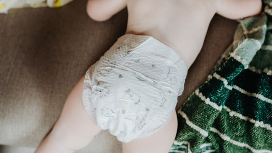 Un bébé portant une couche allongé sur le ventre