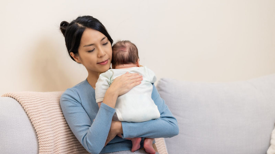 Une maman apaisant le hoquet de bébé