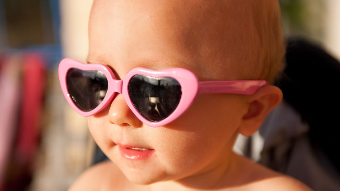 un bébé portant des lunettes de soleil en forme de coeur