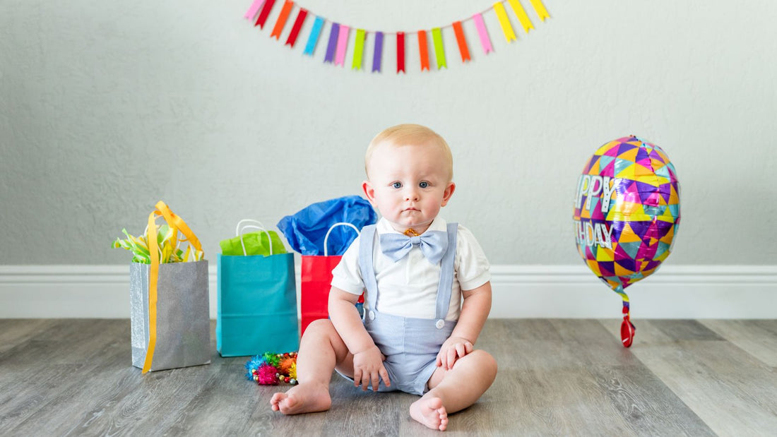 Un bébé d'un an entouré de ses cadeaux d'anniversaire et d'un ballon