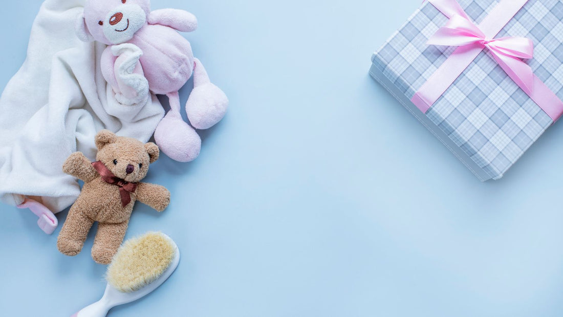 Un coffret naissance avec son contenu exposé, doudou, ourson, une jolie brosse à poil doux