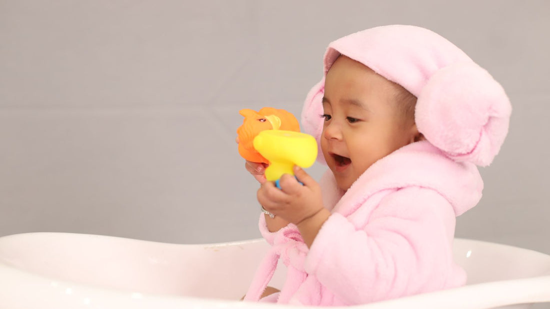 un bébé avec une cape de bain rose