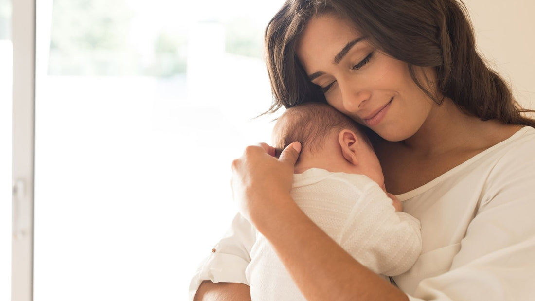 Une maman réconfortant son bébé dans les bras