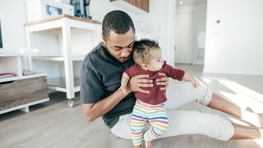 Un parent aidant bébé à faire ses premiers pas