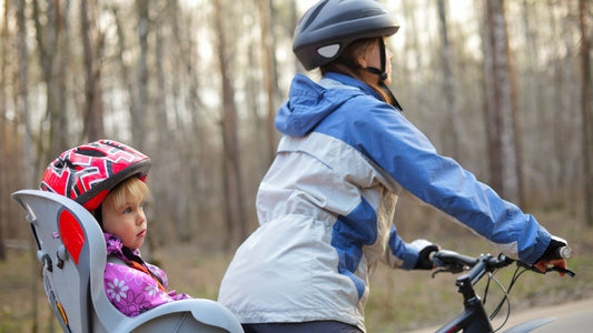 Un bébé sur un porte vélo conduit par sa maman