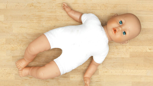 une poupée corolle allongée sur un parquet bois