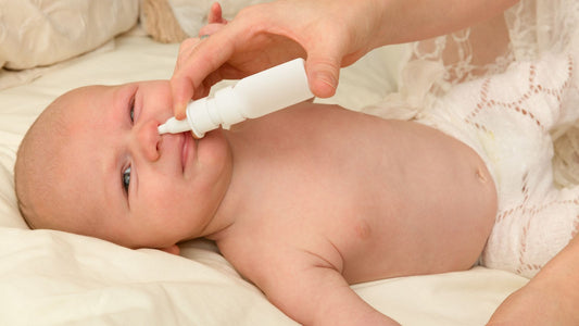Un parent nettoyant le nez de son bébé à l'aide d'une seringue adaptée