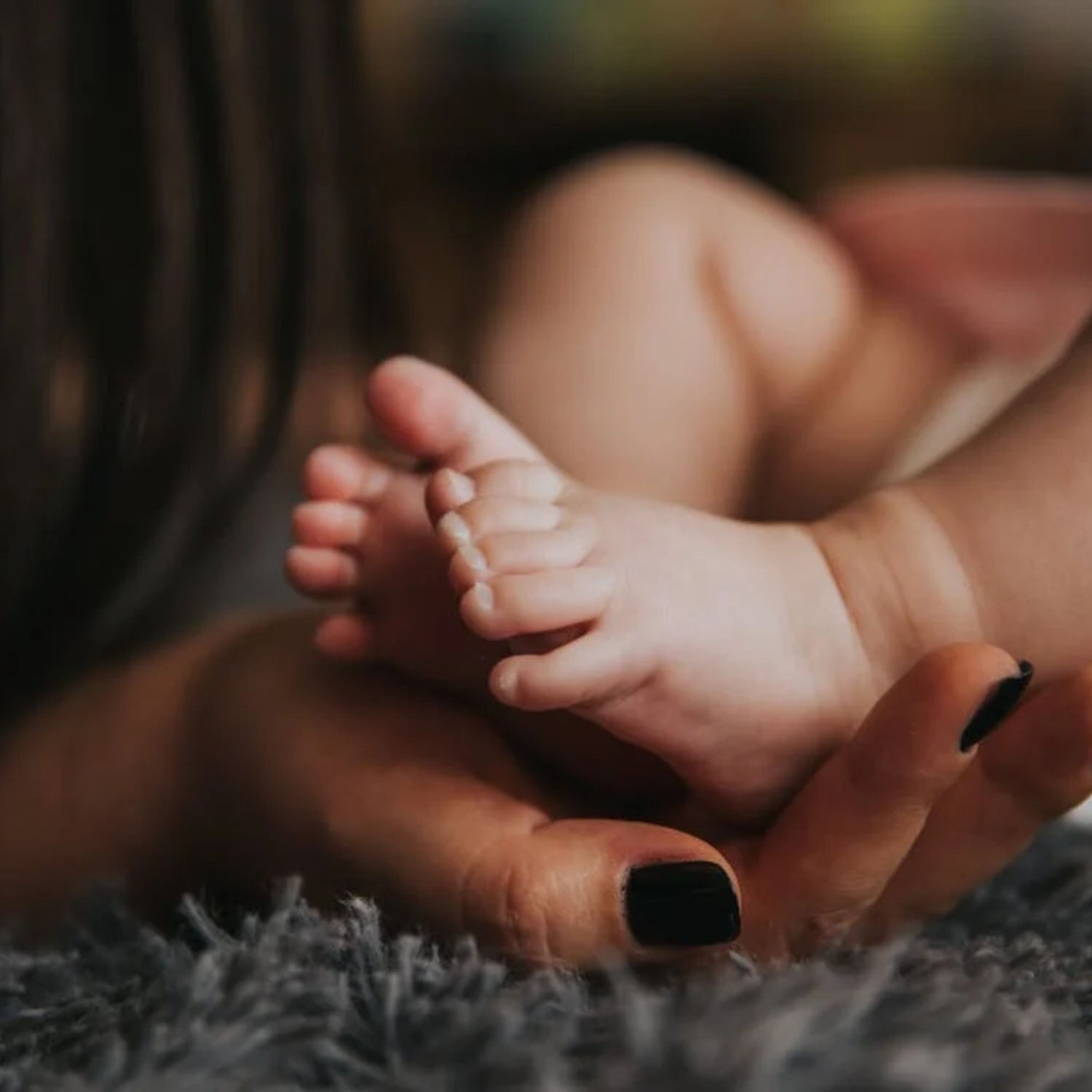 une maman supportant les pieds de bébé